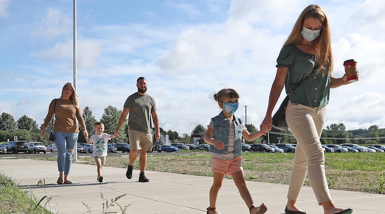 Preschool and kindergarden students walk into Shawnee Elementary School with their parents Wednesday for assessments. BILL LACKEY/STAFF