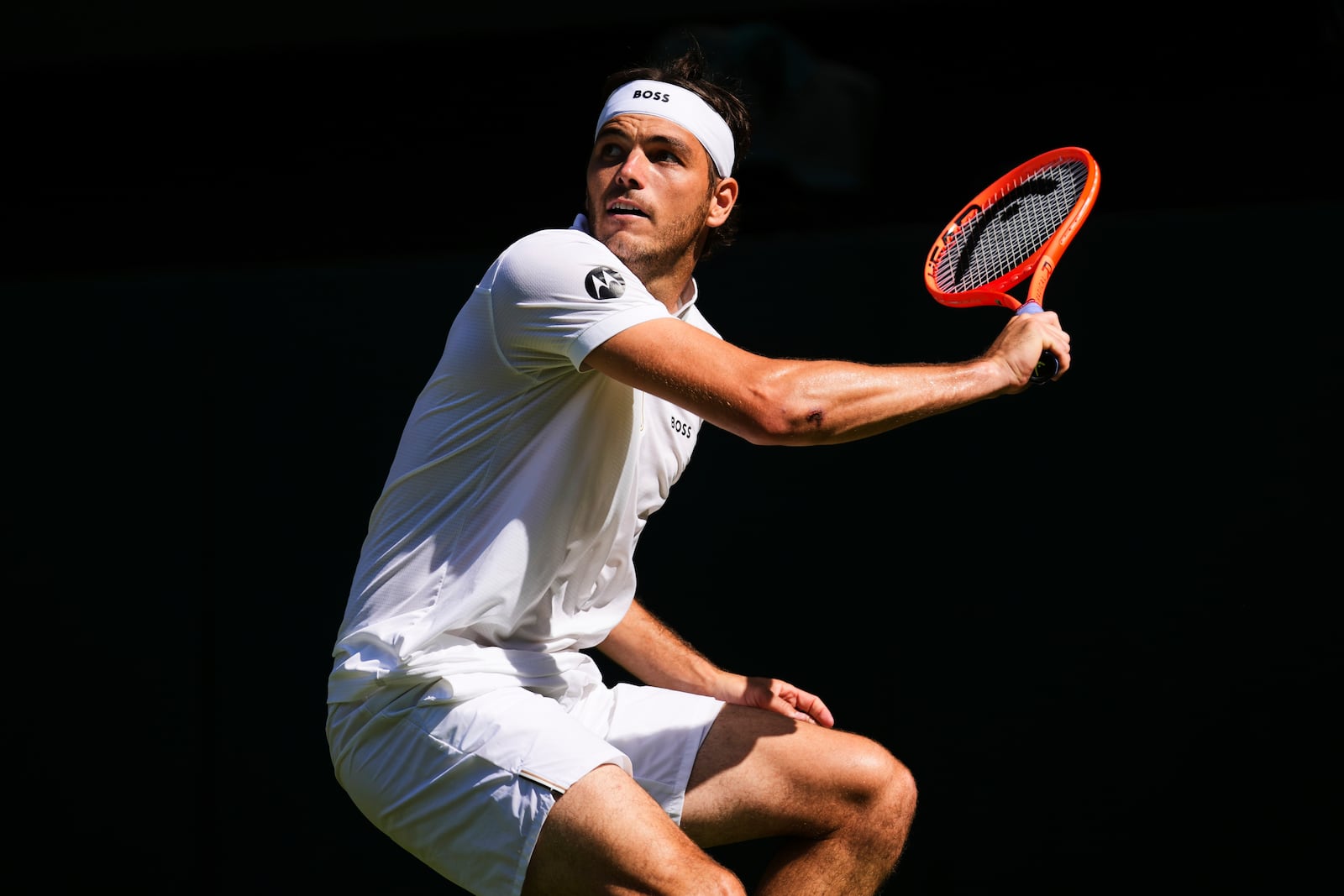 Taylor Fritz of the U.S. returns to Carlos Alcaraz of Spain during the men's semifinal singles match at the Wimbledon Tennis Championships in London, Friday, July 11, 2025.(AP Photo/Joanna Chan)