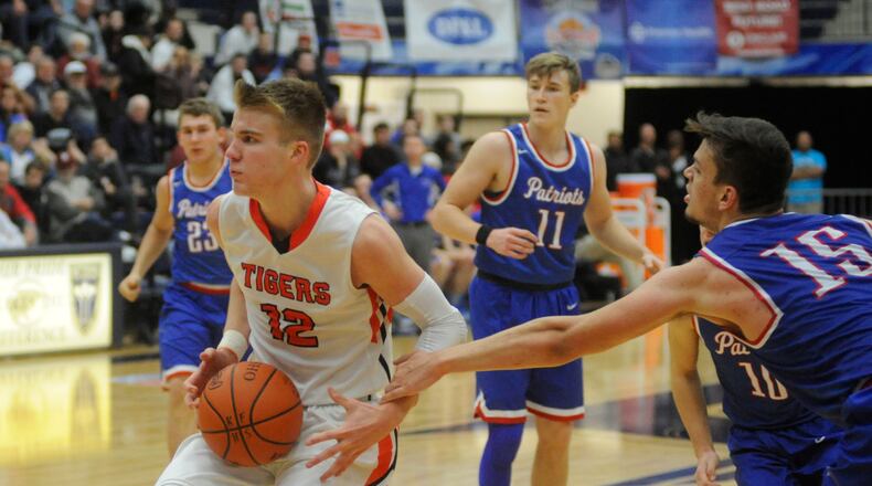 Versailles’ Justin Ahrens (with ball) had 26 points and Trace Couch (15) 24 to lead Tri-Village. MARC PENDLETON / STAFF