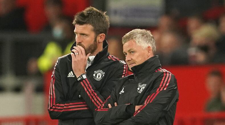 FILE - Manchester United's manager Ole Gunnar Solskjaer, right, and assistant Michael Carrick stand on the touchline during the English League Cup soccer match between Manchester United and West Ham at Old Trafford in Manchester, England, Wednesday, Sept. 22, 2021. (AP Photo/Dave Thompson, File)