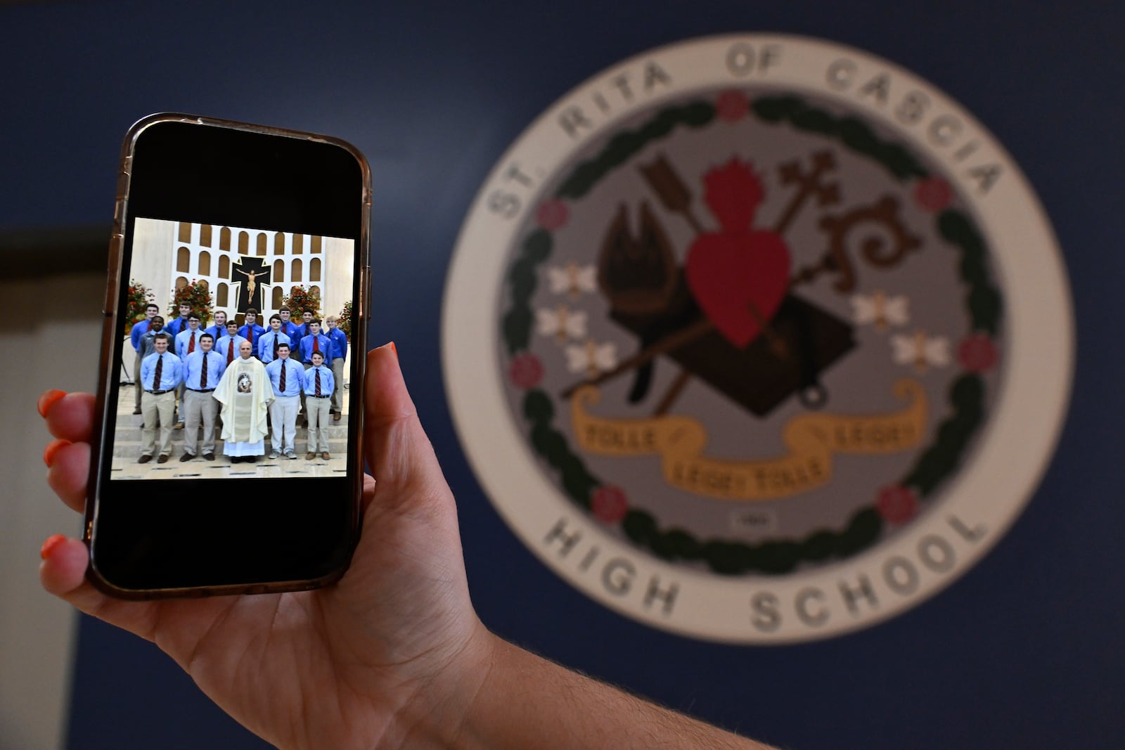 A photo of the new Pope Leo XIV, Chicago native Cardinal Robert Prevost is shown on a phone from when he was a substitute teacher at St. Rita high school Thursday, May 8, 2025, in Chicago. (AP Photo/Paul Beaty)