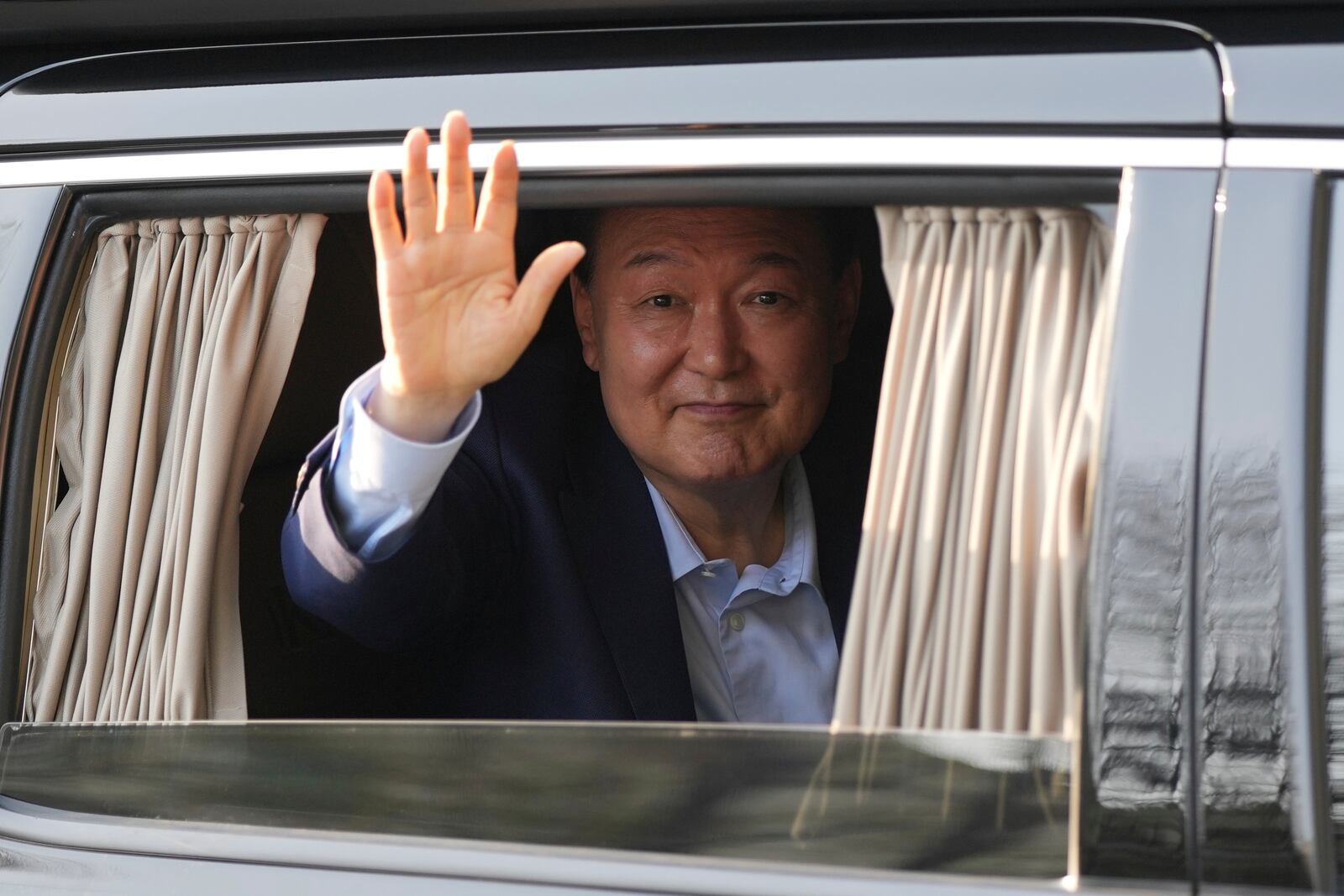 Former South Korean President Yoon Suk Yeol waves upon his arrival at the private residence in Seoul, South Korea, Friday, April 11, 2025. (AP Photo/Lee Jin-man)