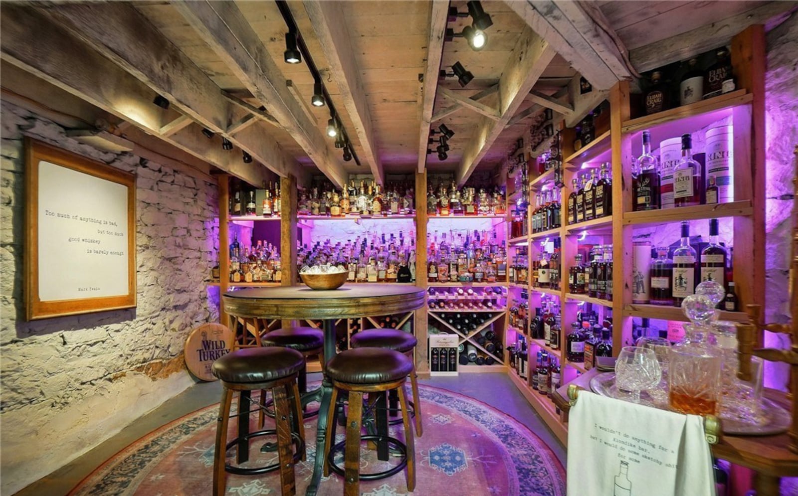 The basement wine cellar has shelving and stone walls.