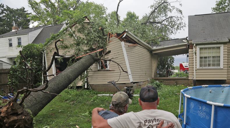 Rob Howard is comforted by his friend Kevin Dancy as they look over the large tree that crushed Howard’s garage Wednesday, June 8, 2022, in the 2500 block of Mechanicsburg Road near Springfield. BILL LACKEY/STAFF
