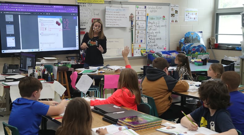 Vicki Flack goes over a math assignment with her second grade class at Triad Elementary. BILL LACKEY/STAFF