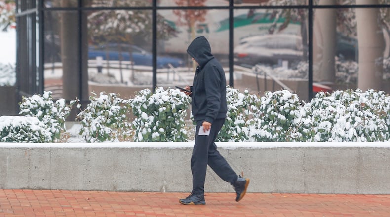A man walks past snowy plants outside Springfield City Hall on Monday, November 10, 2025, in Springfield. JOSEPH COOKE/STAFF