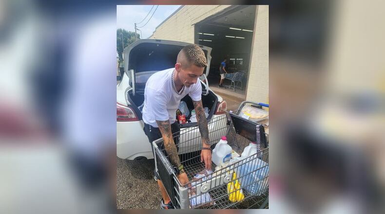 Second Harvest Food Bank Warehouse Associate, Jason Breakall, assists a neighbor during the food bank’s alley emergency food pick-up evening hours. Contributed/Jennifer Brunner, SHFB.