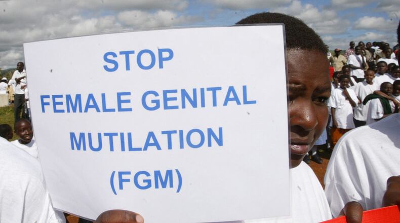 A Masai girl holds a protest sign during the anti-Female Genital Mutilation (FGM) run in Kilgoris, Kenya, April 21, 2007. (AP Photo/Sayyid Azim)