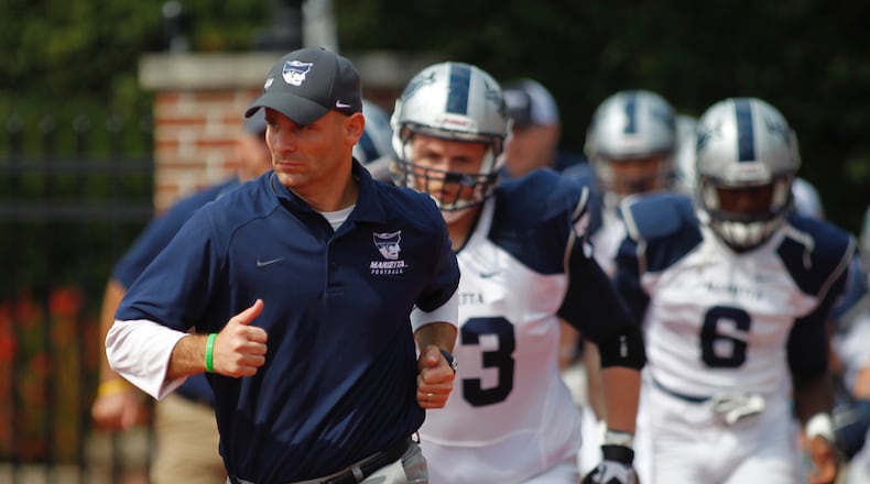 Marietta College head football coach Andy Waddle, a Greenon High School graduate and former defensive coordinator at Wittenberg, leads his team onto the field before a game at Otterbein on Saturday, Sept. 20, 2014, in Westerville. David Jablonski/Staff
