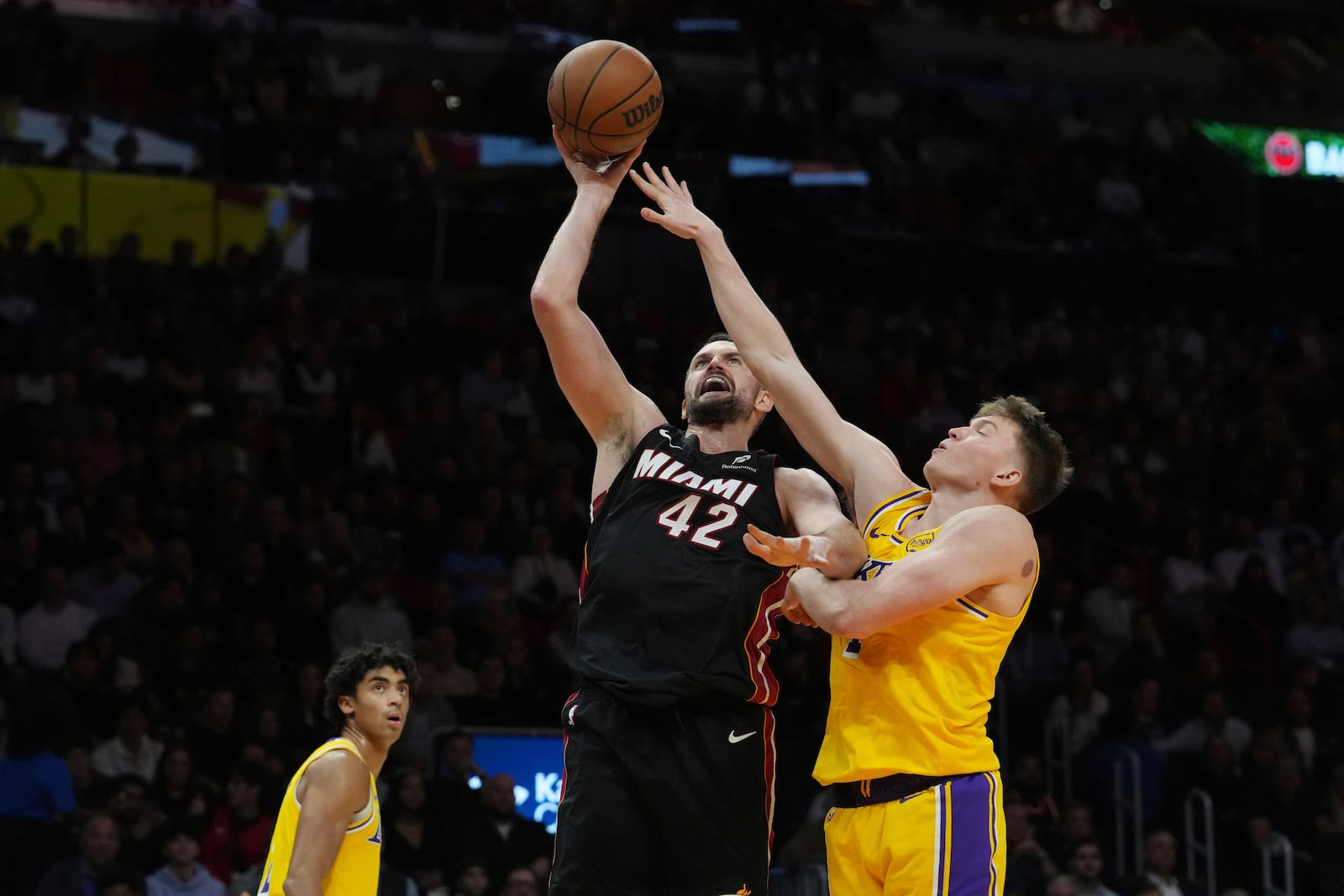 FILE - Miami Heat forward Kevin Love (42) drives to the basket as Los Angeles Lakers guard Dalton Knecht (4) defends during the second half of an NBA basketball game, Dec. 4, 2024, in Miami. (AP Photo/Marta Lavandier, File)