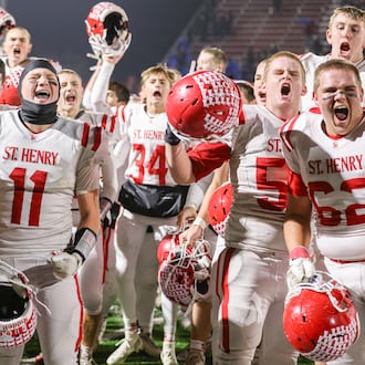 St. Henry players celebrate after defeating Marion Local 24-7 in the Division VII, Region 28 championship on Friday, Nov. 21 at Mercy Health/Wapak Ford Field in Wapakoneta. The Redskins stopped a 76-game winning streak by their Midwest Athletic Conference rival Marion Local. BRYANT BILLING/STAFF