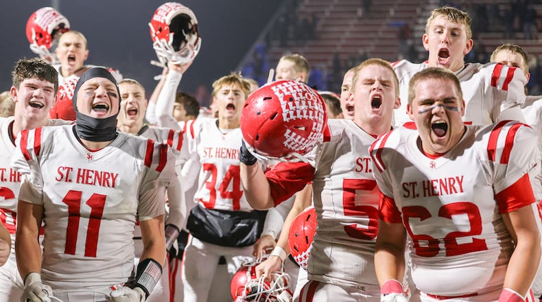 St. Henry players celebrate after defeating Marion Local 24-7 in the Division VII, Region 28 championship on Friday, Nov. 21 at Mercy Health/Wapak Ford Field in Wapakoneta. The Redskins stopped a 76-game winning streak by their Midwest Athletic Conference rival Marion Local. BRYANT BILLING/STAFF