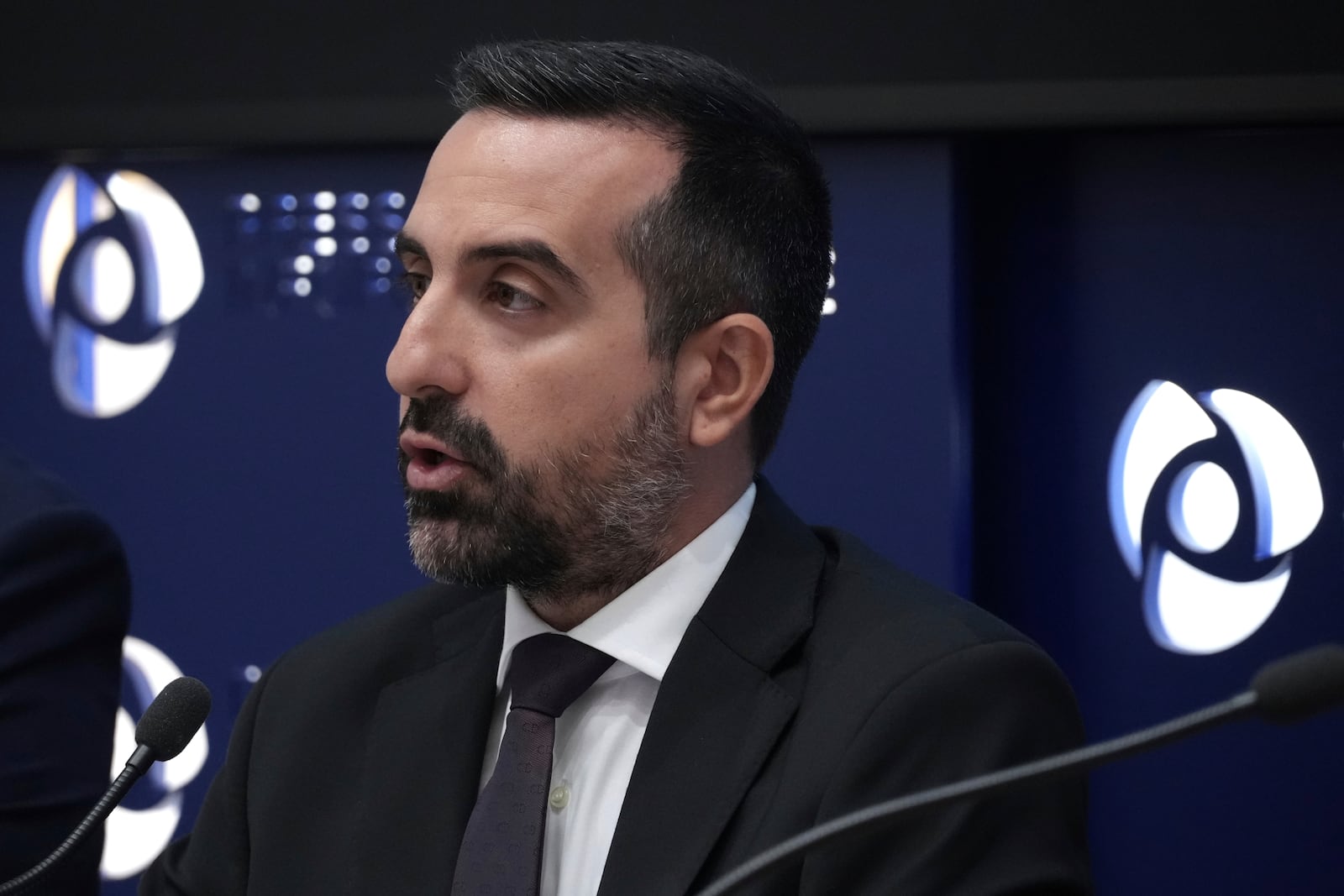 Cyprus' deputy minister for migration Nicholas Ioannides explains how a new voluntary repatriation program for Syrian families living in Cyprus will work during a press conference, at the Press and Informations office in the capital Nicosia, Cyprus, Thursday, May 29, 2025. (AP Photo/Petros Karadjias)