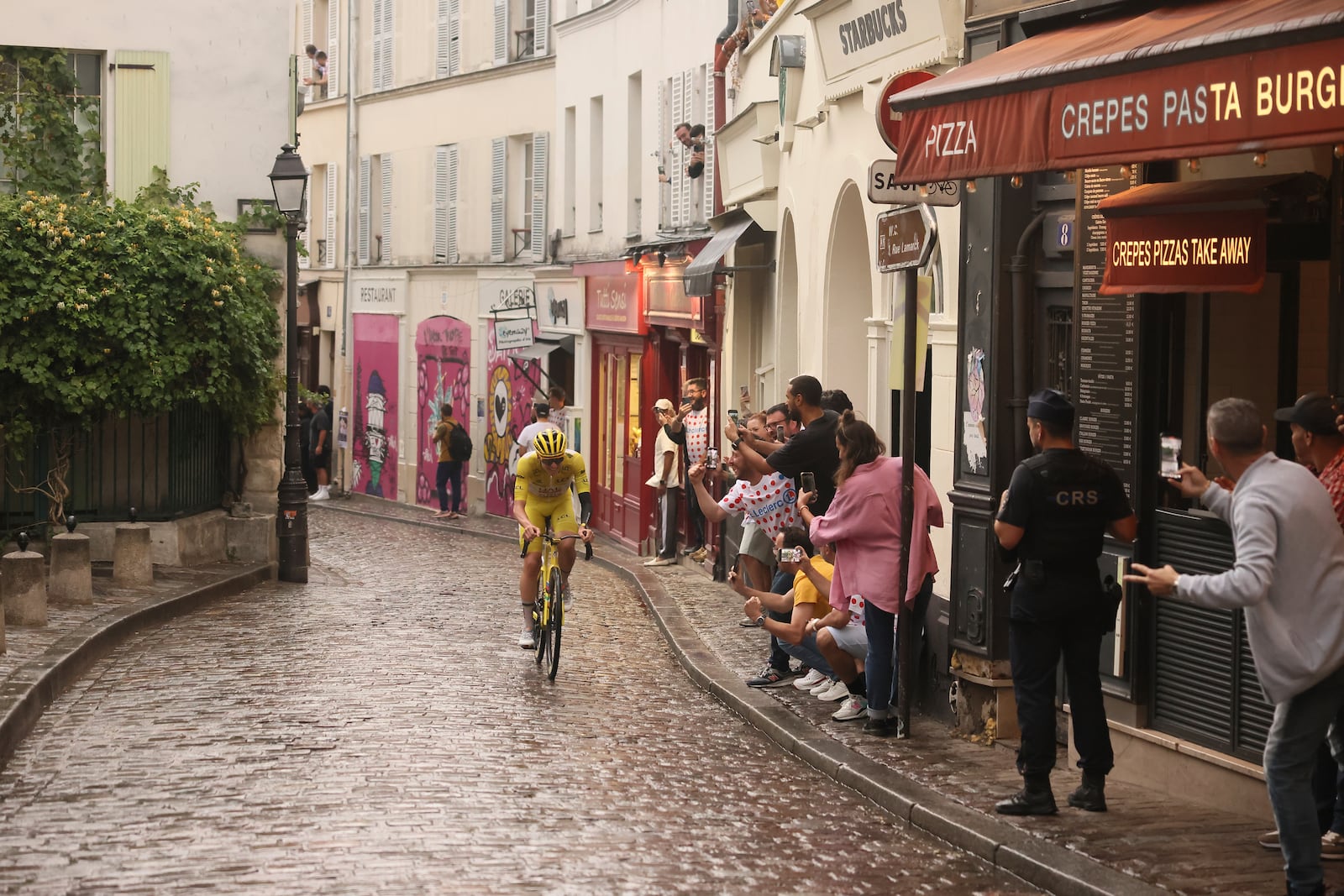 Slovenia's Tadej Pogacar, wearing the overall leader's yellow jersey, pedals at the Place de Tertre in the Montmartre district, during the last stage of the Tour de France cycling race between Mantes-la-Ville and Paris, Sunday, July 27, 2025 in Paris (AP Photo/Thomas Padilla)