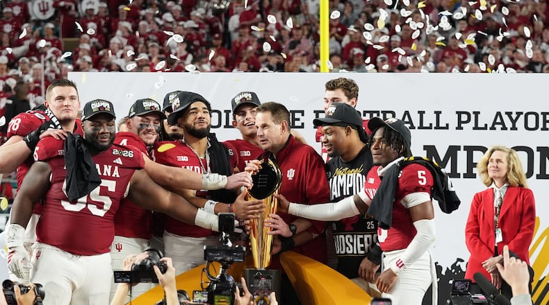 FILE - Indiana head coach Curt Cignetti, third from right, stands with players and the trophy after Indiana defeated Miami in a College Football Playoff national championship game, Jan. 19, 2026, in Miami Gardens, Fla. (AP Photo/Lynne Sladky, file)