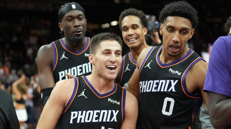Phoenix Suns guard Collin Gillespie (12) celebrates with teammates after hitting the winning shot against the Minnesota Timberwolves during the second half of an NBA Cup basketball game, Friday, Nov. 21, 2025, in Phoenix. (AP Photo/Rick Scuteri)