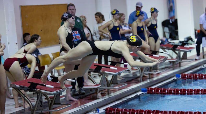 Shawnee High School junior Lola Derr leaps into the pool after junior Avery Young touches the wall during a relay race at the 2026 Clark County Swimming Championships on Sunday, Feb. 8 at the Wittenberg Natatorium. RODNEY GETZ / CONTRIBUTED PHOTO