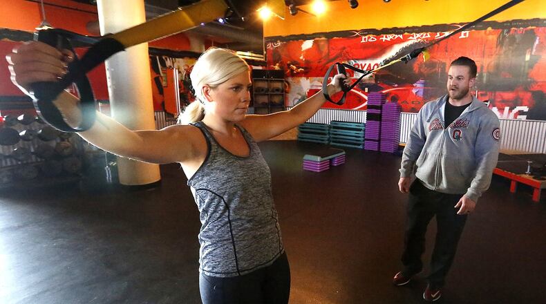 Blaine Wright, a fitness trainer at the Fitness Cellar, works with Logan Sherrock Tuesday at the gym. Bill Lackey/Staff