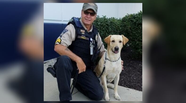 Gunner, a Labrador retriever working as a TSA explosive detection canine, celebrated his retirement this month from the Dayton International Airport. He is shown with his handler and now owner Sgt. Ted Priest. CONTRIBUTED