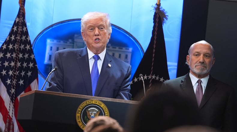 President Donald Trump speaks during a press briefing at the White House, Friday, Feb. 20, 2026, in Washington, as Commerce Secretary Howard Lutnik, looks on. (AP Photo/Evan Vucci)