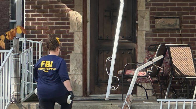 An FBI agent enters a home in a Dearborn, Mich., neighborhood on Friday, Oct. 31, 2025. (AP Photo/Mike Householder)