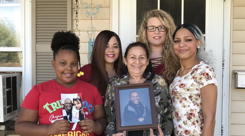 Angela Bowshier and her grandchildren hold photos of her late long-time boyfriend Jesse Clark, who along with Angela helped raise their family in her Fuller Center home, which she paid off in August. They are, left to right: Akeela Crossley, Tamika Rogan, Bowshier, Julie Rogan and India Rogan. Not pictured is Kylen Harrison. CONTRIBUTED
