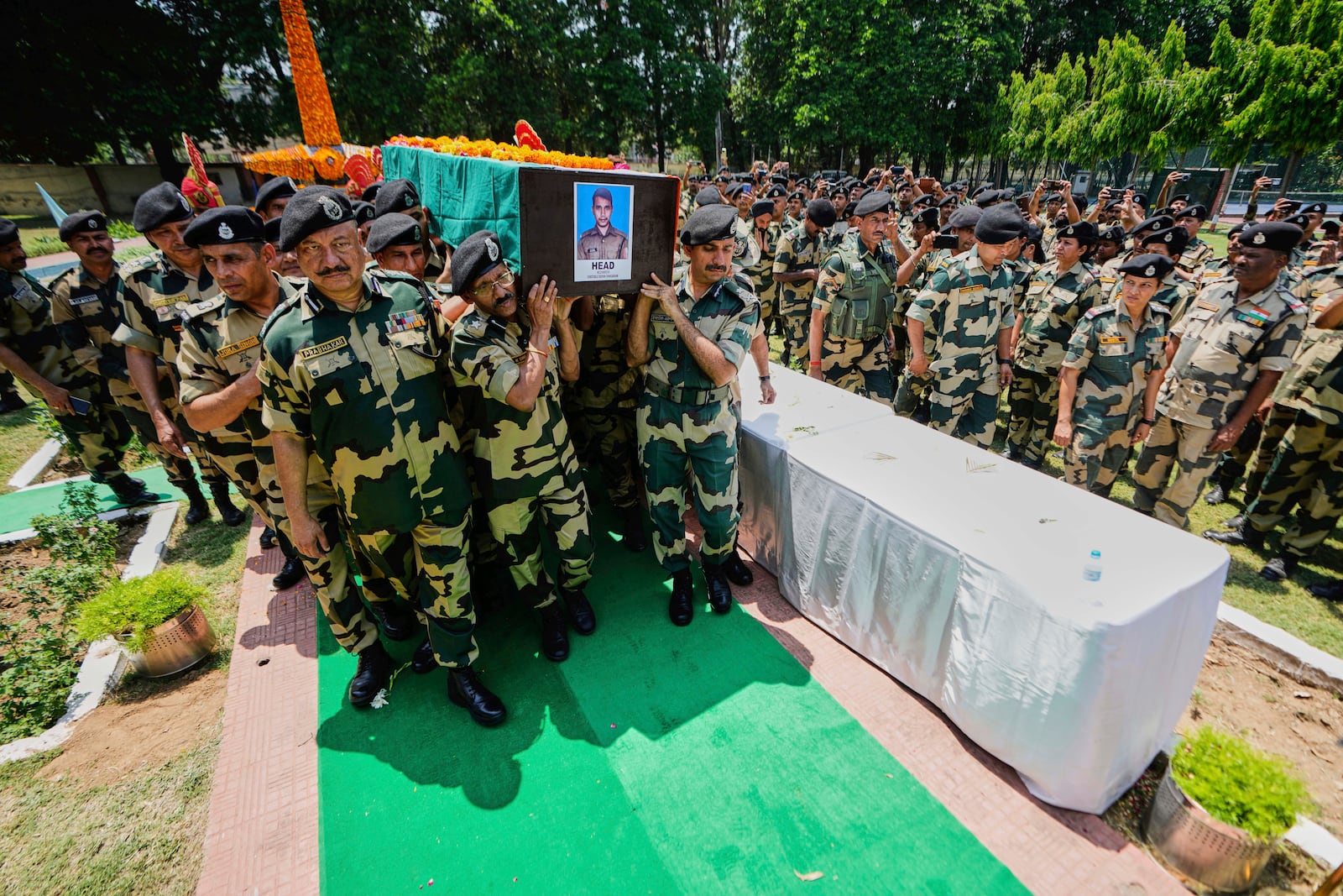 Indian Border Security Force (BSF) Soldiers carry a coffin containing the remains of a fellow soldier Deepak Chimngakham, who was killed in cross border Pakistani artillery shelling, in Jammu, India, Monday, May 12, 2025.(AP Photo/Channi Anand)