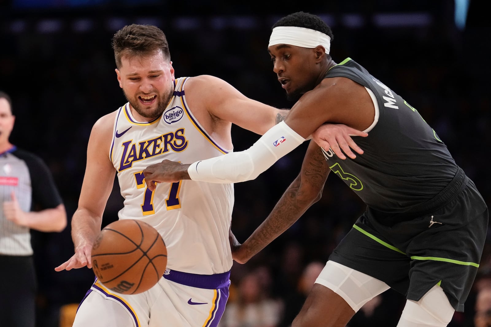 Minnesota Timberwolves forward Jaden McDaniels, right, reaches in on Los Angeles Lakers guard Luka Doncic during the first half in Game 1 of an NBA first-round playoff series Saturday, April 19, 2025, in Los Angeles. (AP Photo/Mark J. Terrill)