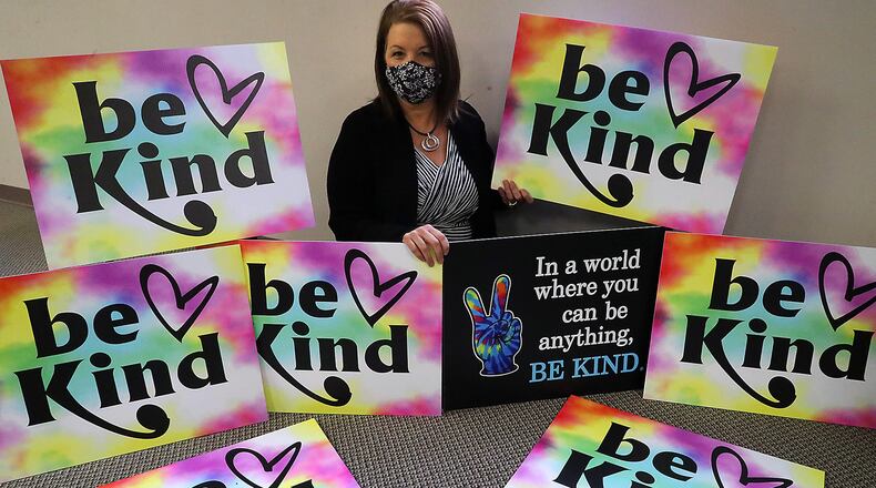 Kristy Thome, Administrative Assistant/Clerk of Courts for Enon, with the "Be Kind" signs she came up with Thursday. BILL LACKEY/STAFF