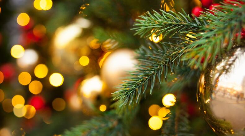 Christmas outdoor background with fir tree branches, decorations and blurred lights on back