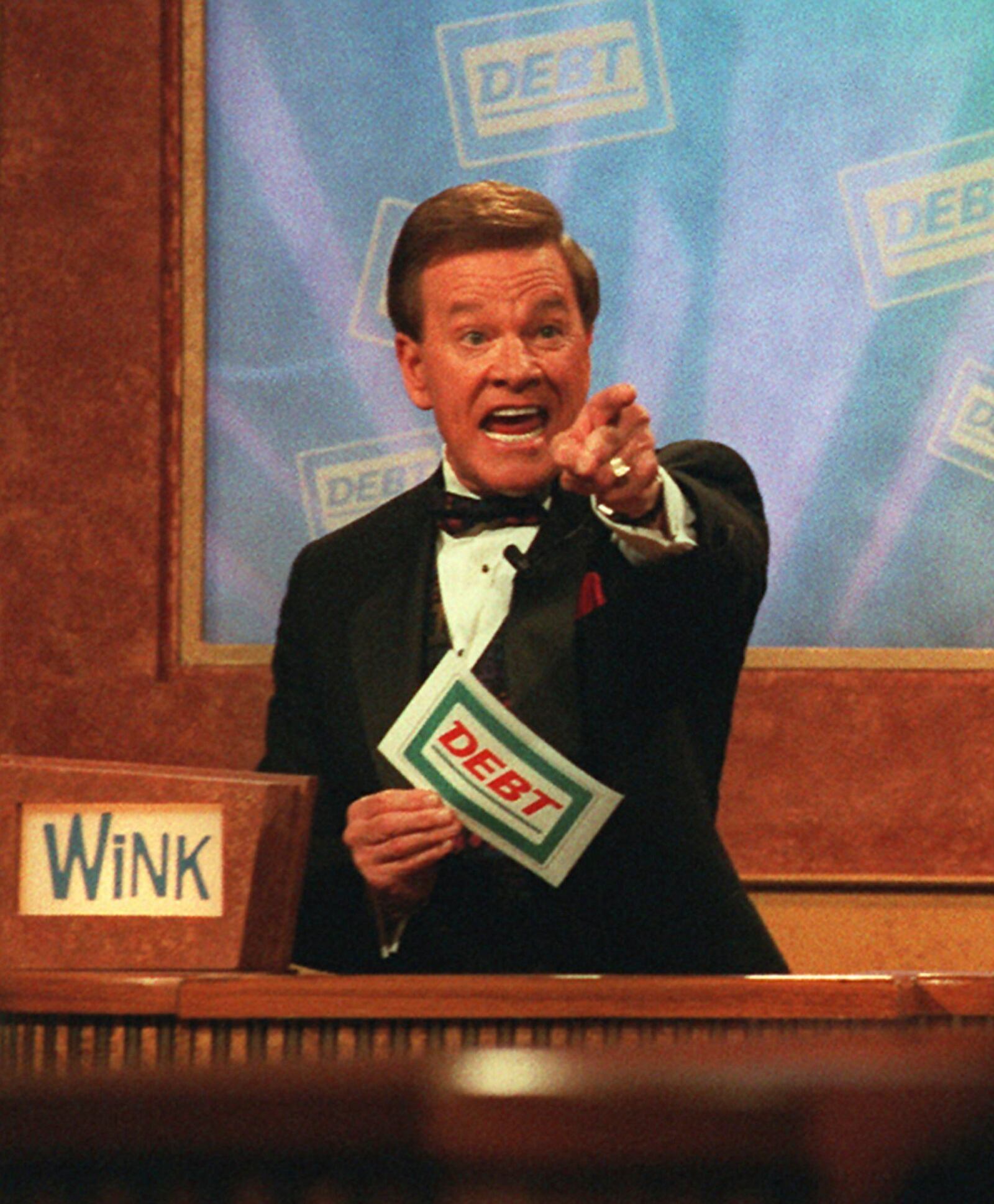 FILE - Host Wink Martindale indicates a correct answer to a contestant during the taping of the television game show "Debt," in Los Angeles, May 22, 1997. (AP Photo/Nick Ut, File)
