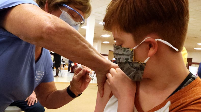 Piper Atkinson, 16, gets her first COVID vaccine injection Tuesday at the Clark County vaccine distribution center at the Upper Vally Mall. BILL LACKEY/STAFF