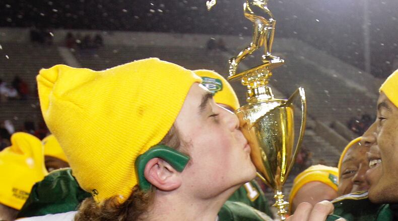 St. Edward quarterback Kevin Burke, left, kisses the trophy after St. Edward beat Wayne 35-28 in the Division I high school football championship football game Saturday, Dec. 4, 2010, in Canton, Ohio. (AP Photo/Tony Dejak)