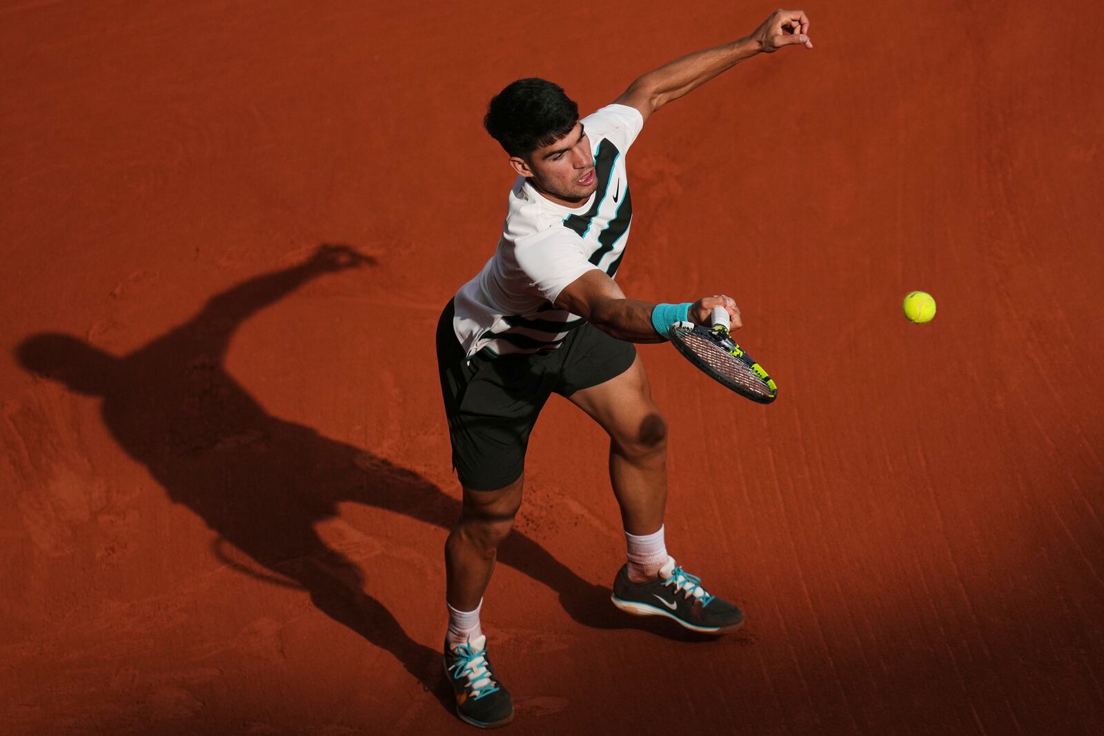 Spain's Carlos Alcaraz returns the ball to Ben Shelton of the U.S. during their fourth round match of the French Tennis Open, at the Roland-Garros stadium, in Paris, Sunday, June 1 2025. (AP Photo/Christophe Ena)
