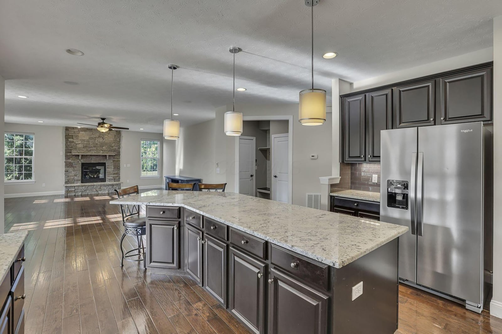 The kitchen is open to the family room. It has granite countertops and tile backsplash. The hardwood flooring flows throughout both rooms. CONTRIBUTED