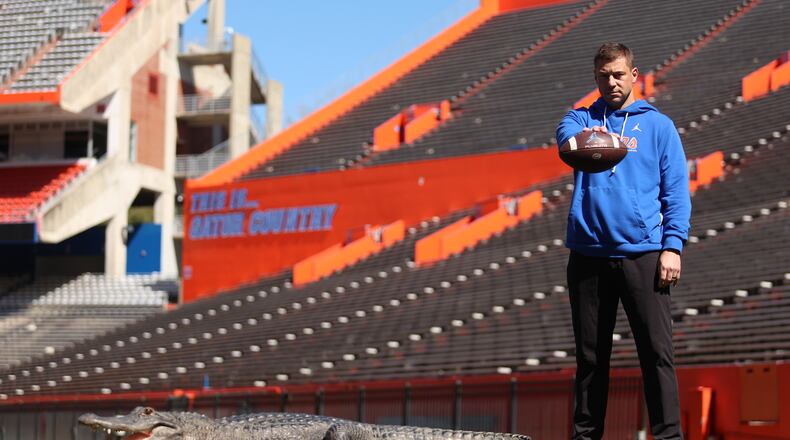 This photo provided by the University of Florida shows Florida football head coach Jon Sumrall posing with an alligator named Helene inside Ben Hill Griffin Stadium, Tuesday, Feb. 24, 2026, in Gainesville, Fla. (Jordan Perez/University of Florida via AP)