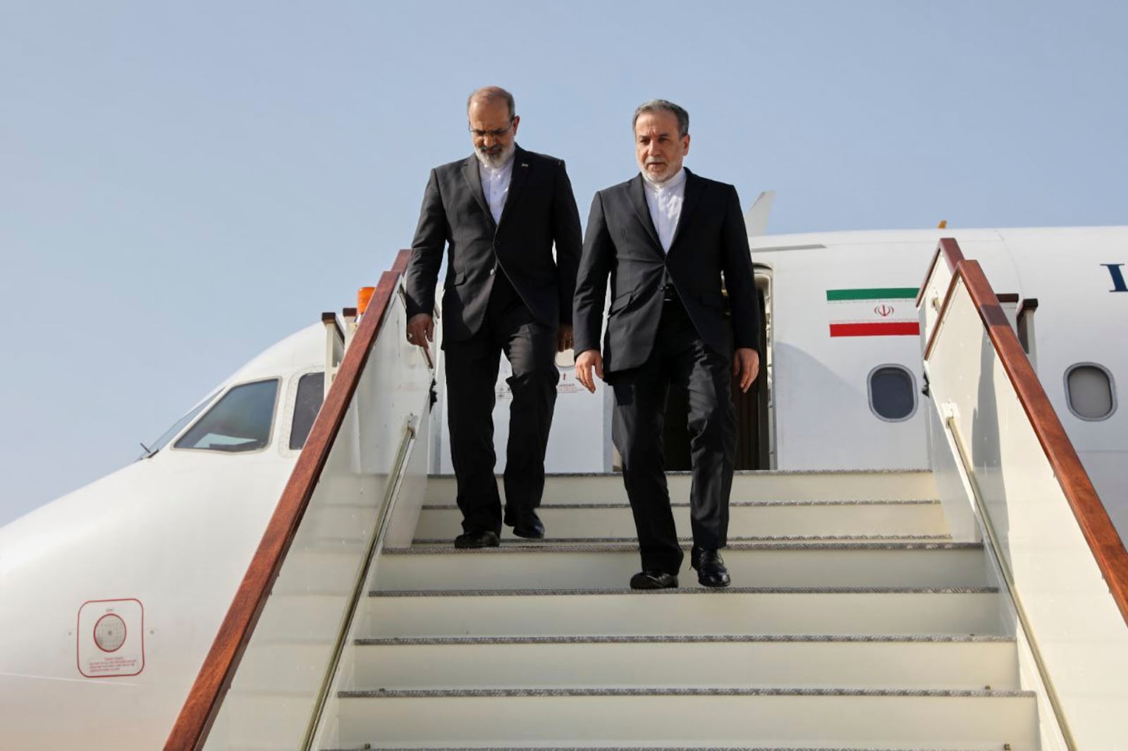 In this photo released by Iranian Foreign Ministry, Iranian Foreign Minister Abbas Araghchi, right, steps out from his plane as he arrives at Muscat, Oman, Friday, April 25, 2025, a day prior to negotiations with U.S. Mideast envoy Steve Witkoff. (Iranian Foreign Ministry via AP)