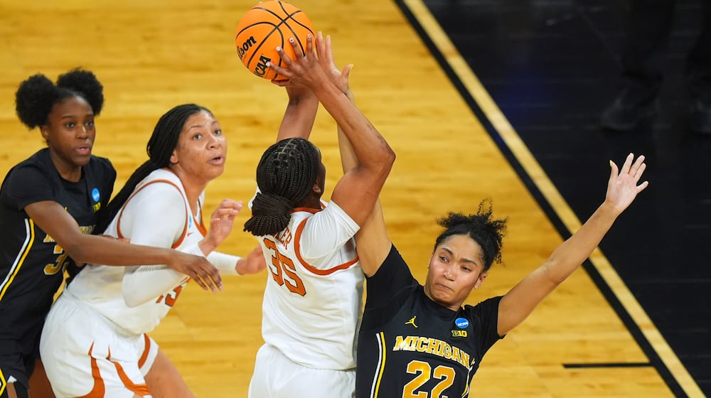 Texas forward Madison Booker (35) shoots on Michigan forward Kendall Dudley (22) during the first half in the Elite Eight of the NCAA college basketball tournament, Monday, March 30, 2026, in Fort Worth, Texas. (AP Photo/LM Otero)