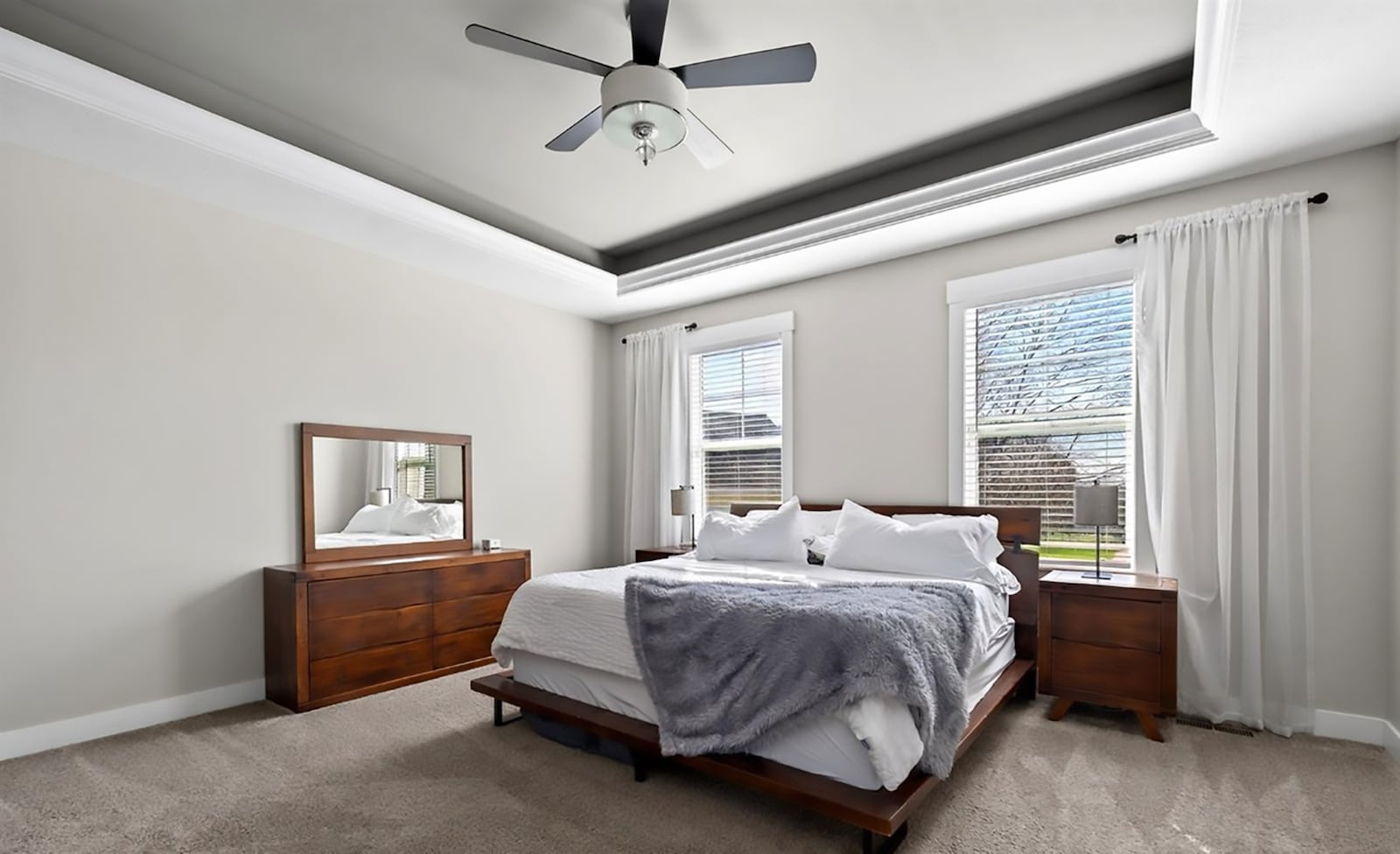 The primary bedroom suite has neutral carpeting, a tray ceiling and a ceiling fan. there is an ensuite bathroom and two walk in closets. CONTRIBUTED