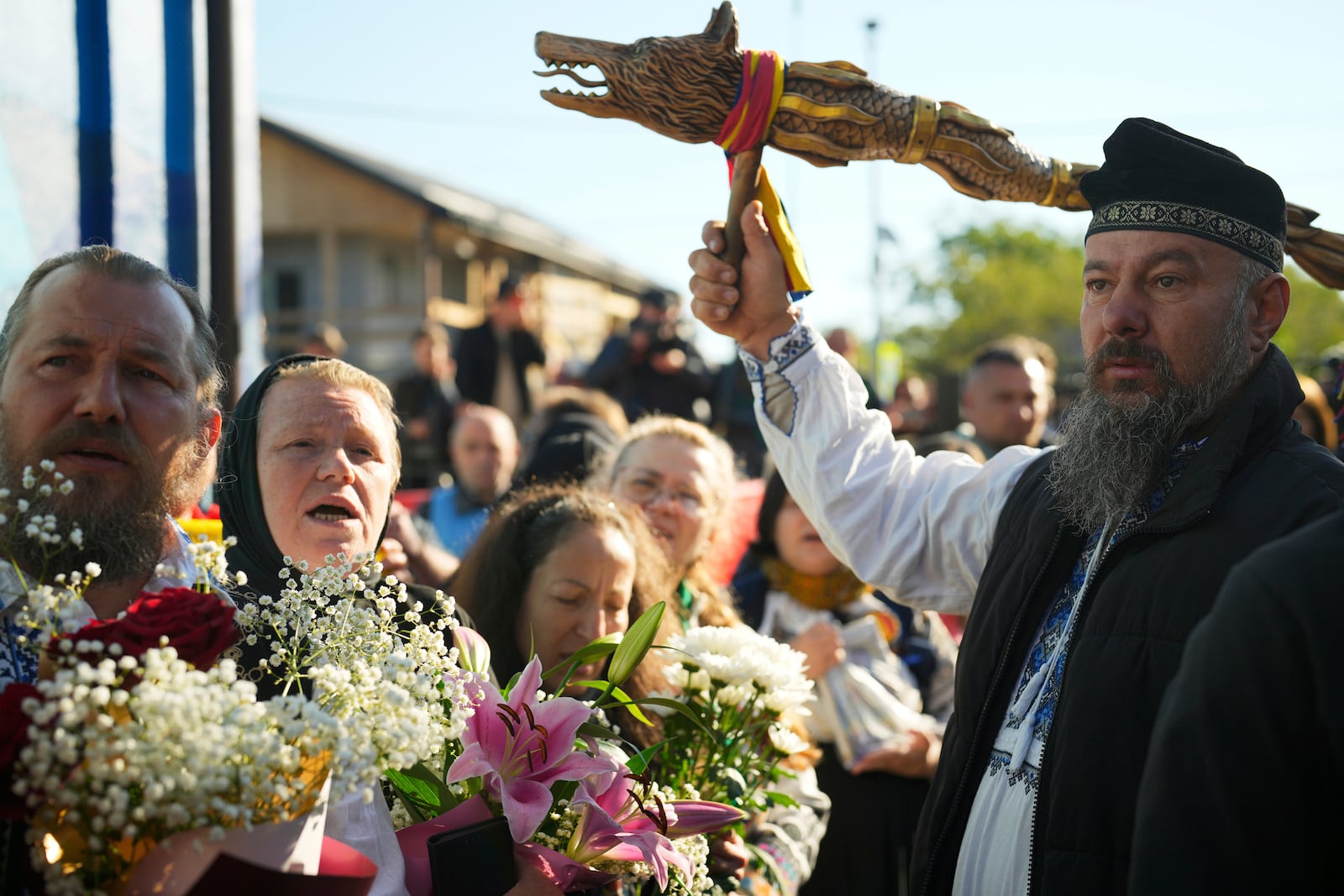 Supporters of Presidential candidate George Simion and Calin Georgescu, winner of the first round of last year's annulled election, gather in front of a polling station in the second round of the country's presidential election redo in Mogosoaia, Romania, Sunday, May 18, 2025. (AP Photo/Vadim Ghirda)