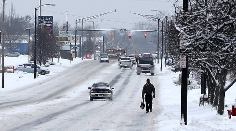 A man walks with a snow shovel in the street along South Limestone Street during last month’s frigid cold weather. BILL LACKEY/STAFF
