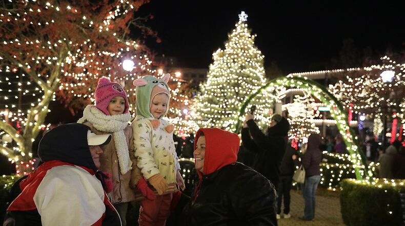 A family poses for a picture on the Springfield Esplanade during the Grand Illumination Friday evening. BILL LACKEY/STAFF