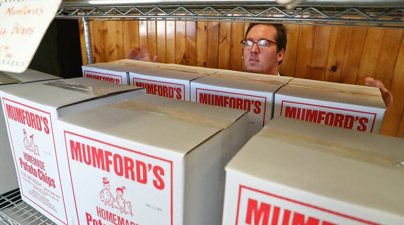 Cody Pack, an employee at Mumford’s Potato Chips, stocks a shelf with boxes of the chips Tuesday. BILL LACKEY/STAFF