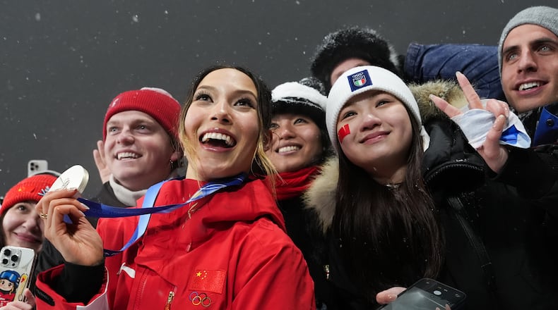 Silver medalist China's Eileen Gu celebrates with fans after the women's freestyle skiing big air finals at the 2026 Winter Olympics, in Livigno, Italy, Monday, Feb. 16, 2026. (AP Photo/Gregory Bull)