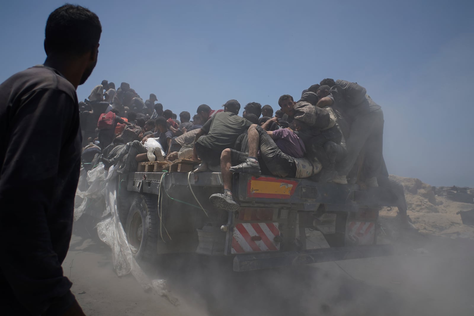 Palestinians hold onto an aid truck returning to Gaza City from the northern Gaza Strip on Tuesday, July 22, 2025. (AP Photo/Jehad Alshrafi)
