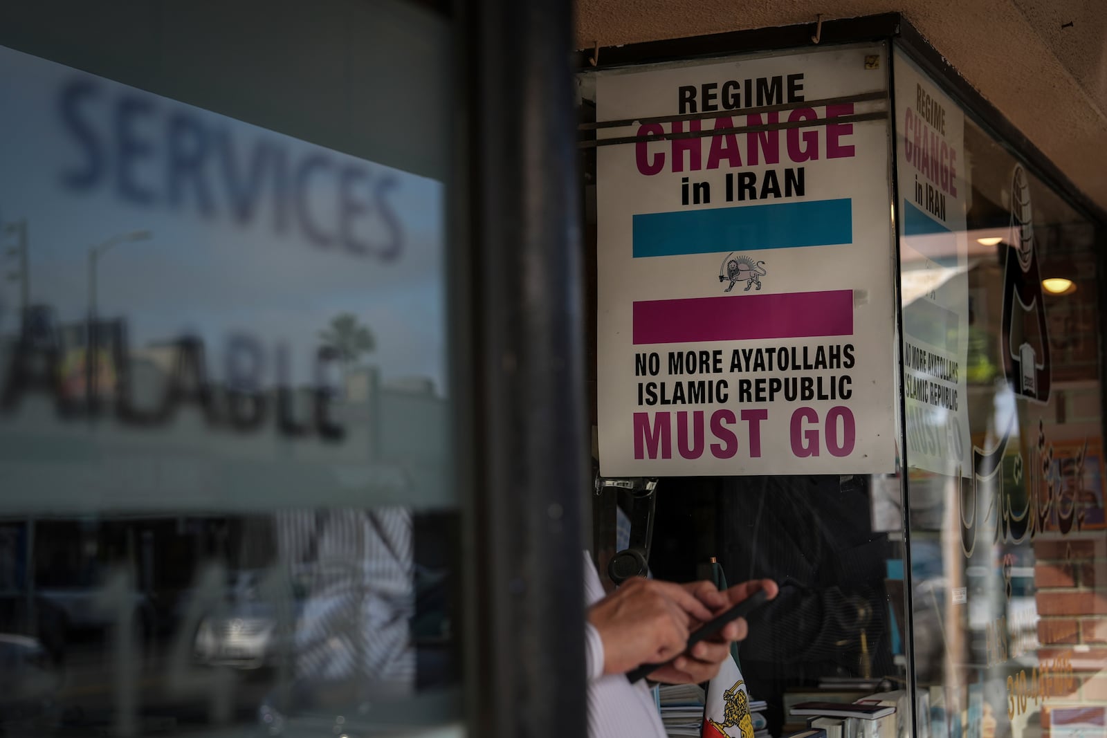 Posters calling for regime change in Iran are displayed in the window of Sam Beykzadeh's bookstore in the "Tehrangeles" neighborhood of Los Angeles Tuesday, June 24, 2025. (AP Photo/Jae C. Hong)