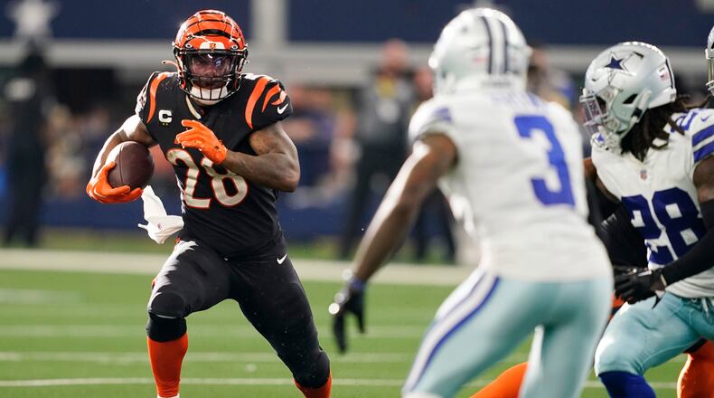 Cincinnati Bengals running back Joe Mixon (28) looks for running room as Dallas Cowboys cornerback Anthony Brown (3) close in during the second half of an NFL football game Sunday, Sept. 18, 2022, in Arlington, Tx. (AP Photo/Tony Gutierrez)