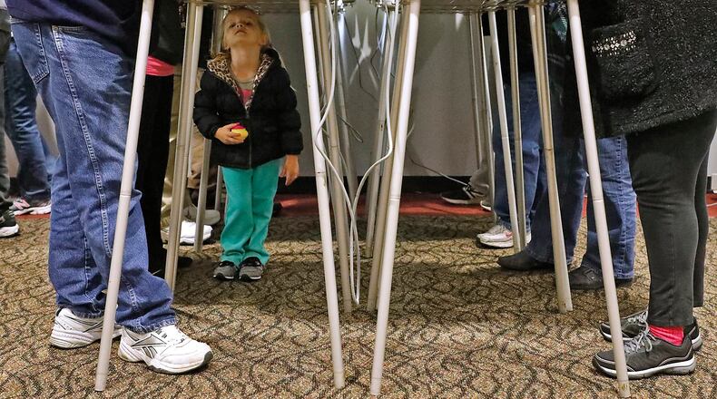 Kenzie Eisen, 4, plays under the voting booths as her mother casts her vote in November at a Clark County election poll. Bill Lackey/Staff
