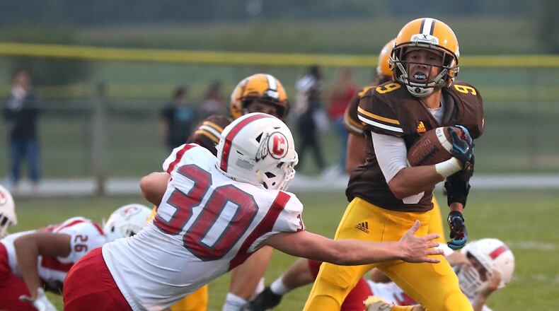 Kenton Ridge’s Drew Miller avoids a tackle by Carlisle’s Brice Naylor. BILL LACKEY/STAFF