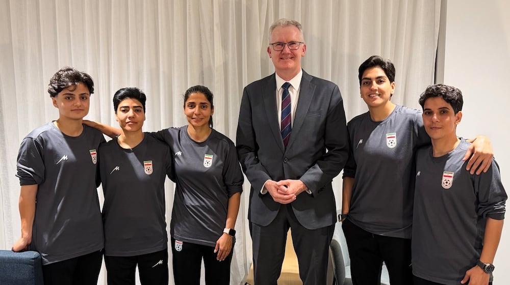 In this photo supplied by Australia's Minister for Home Affairs Tony Burke's office, the Minister Tony Burke, center, poses in an undisclosed location with five Iranian women soccer players who have been granted asylum in Australia, Tuesday, March 10, 2026. (Australia Ministry of Home Affairs via AP)